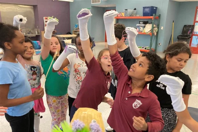 Group of kids lifting sock puppets.